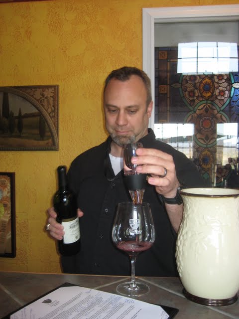 Justin Bogady pouring red wine through a wine aerator