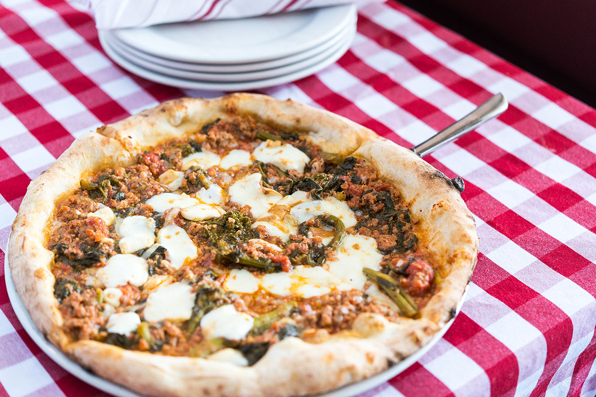 pizza with cheese and meat on picnic table