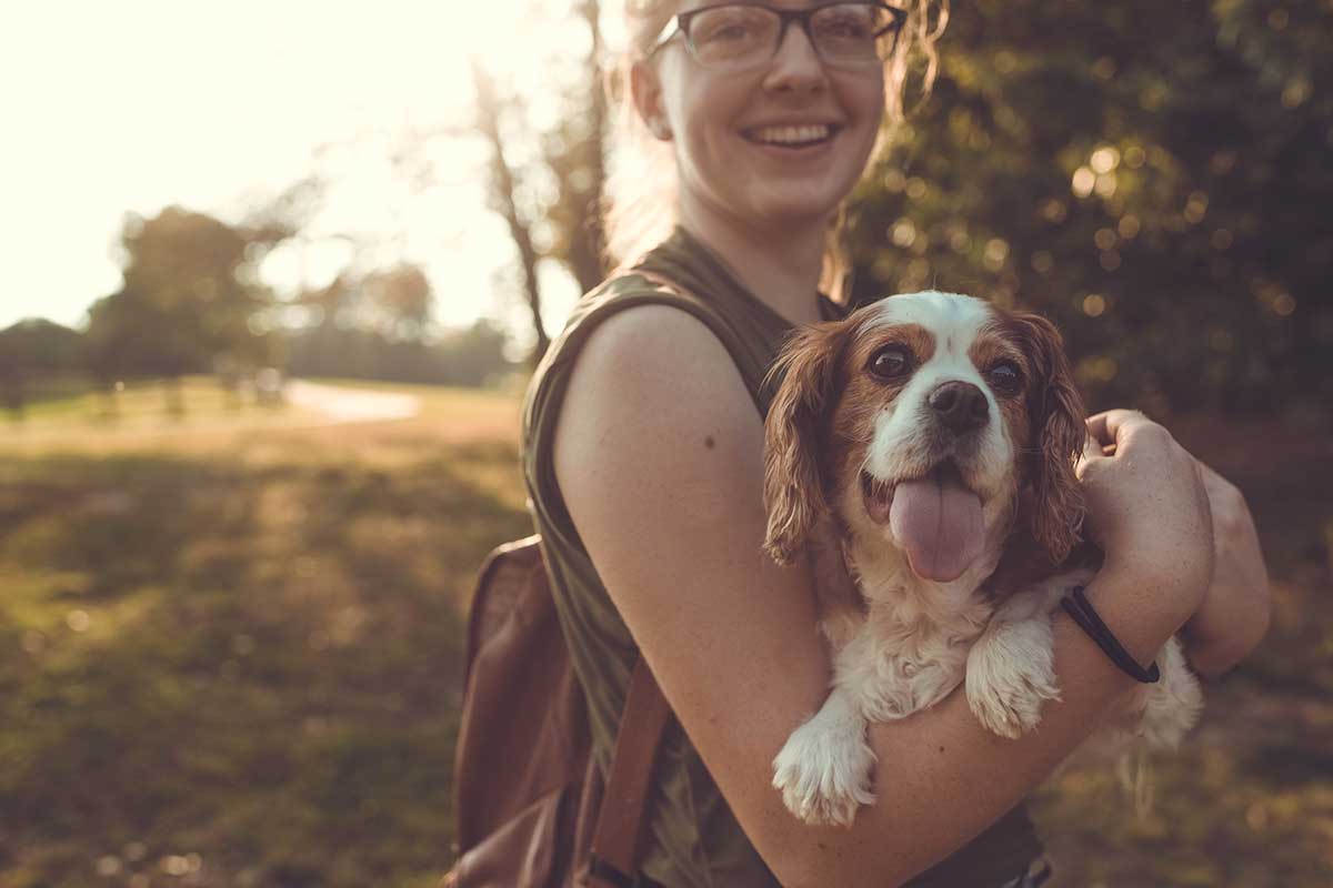 woman holding dog outside