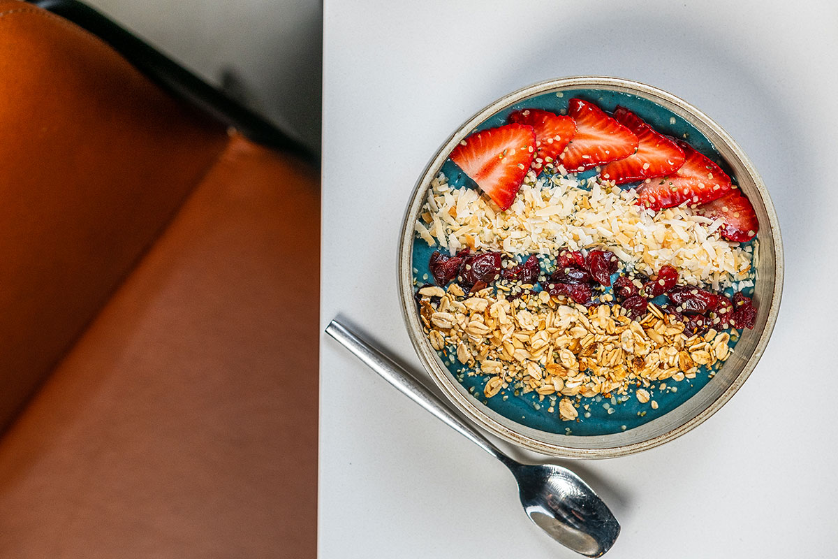 blue-base açaí bowl with fruit and granola atop